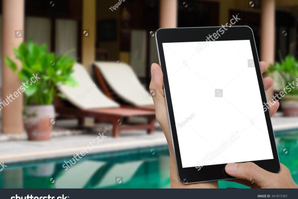 stock-photo-man-hands-holding-tablet-computer-with-blurred-indoor-swimming-pool-background-341815301